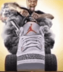 a man is riding a lawn mower made out of a pair of air jordan sneakers .