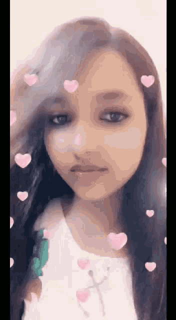 a girl with long hair and pink hearts around her face .