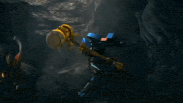a cartoon robot is fighting another robot in a dark cave .
