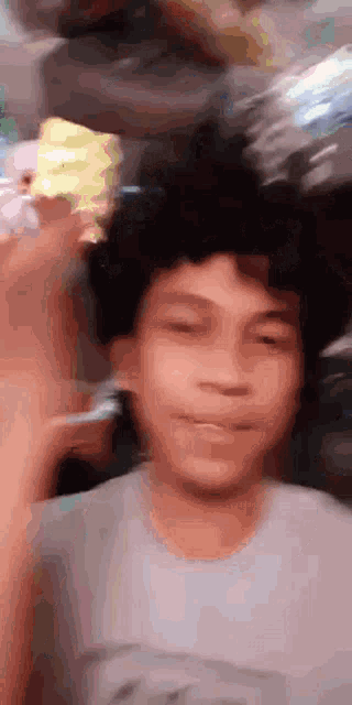 a blurry picture of a young boy with his eyes closed and a sponge in his hair
