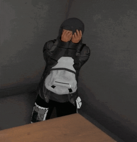 a person covering their face with their hands while wearing a hoodie