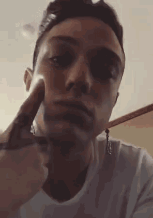 a close up of a person 's face with their finger on their face .
