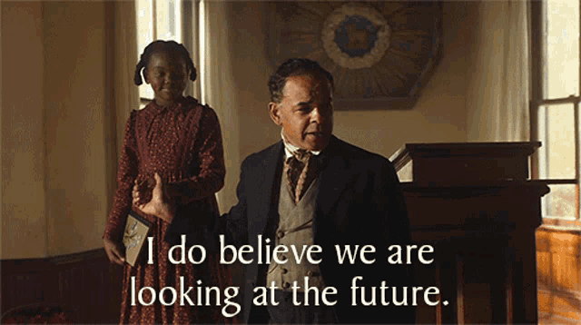 a man in a suit stands next to a little girl who says i do believe we are looking at the future