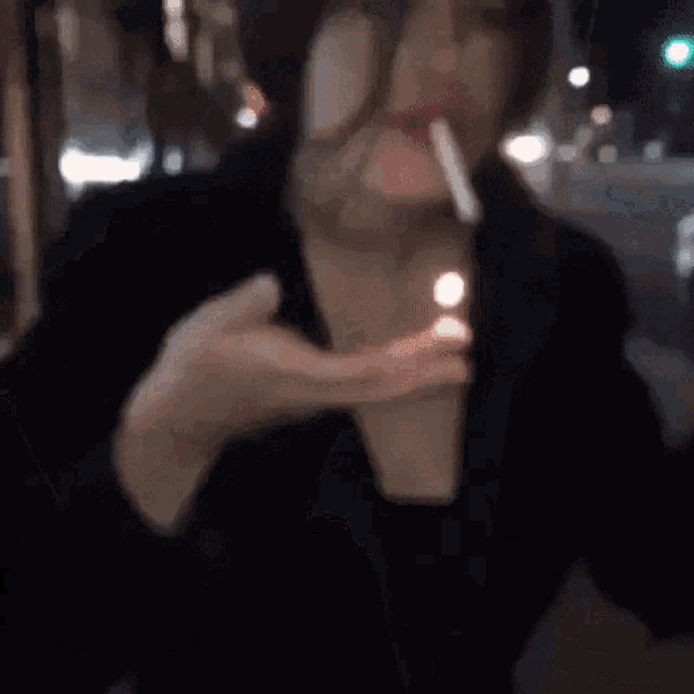 a woman is lighting a cigarette with a match .