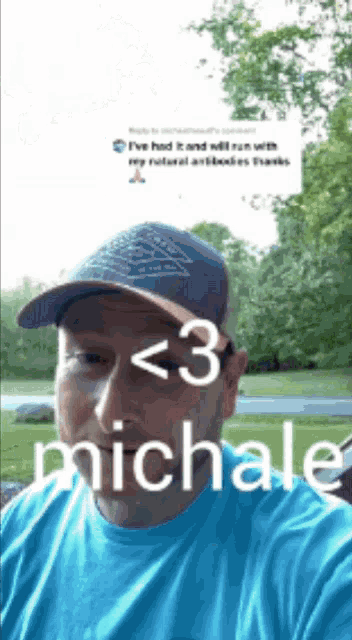 a man wearing a blue shirt and a hat has the name michale on his forehead