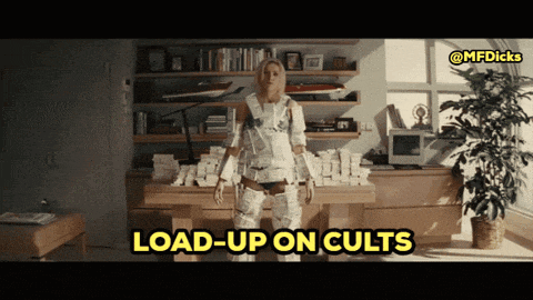 a woman wrapped in toilet paper is standing in front of a desk that says load-up on cults