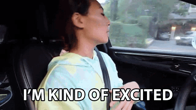 a woman is sitting in the back seat of a car and saying i 'm kind of excited .