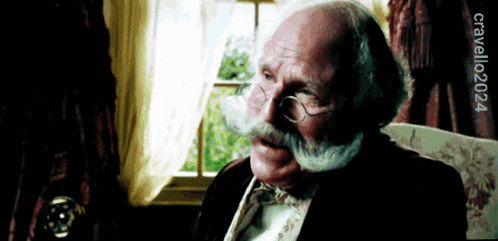 a man with glasses and a mustache is sitting in front of a window with the year 2024 on the bottom right