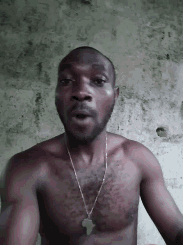 a man without a shirt is wearing a necklace with an africa pendant