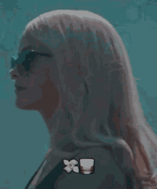 a woman wearing a mask and a headset is holding a glass of whiskey .