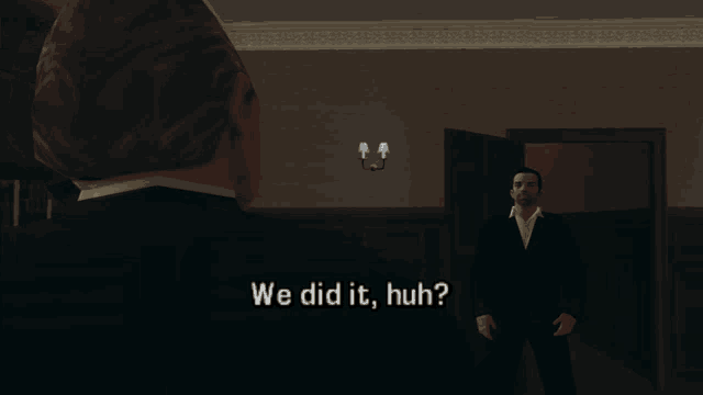 a man in a suit is talking to another man in a dark room and they both say we did it huh