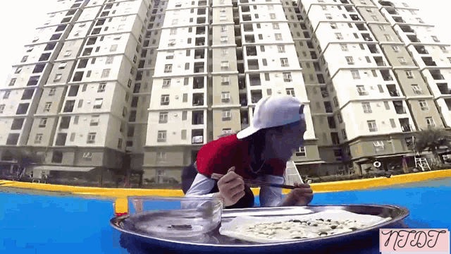 a man is eating food in front of a tall building with the word nerds on the bottom