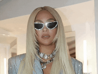 a close up of a woman wearing sunglasses and a choker