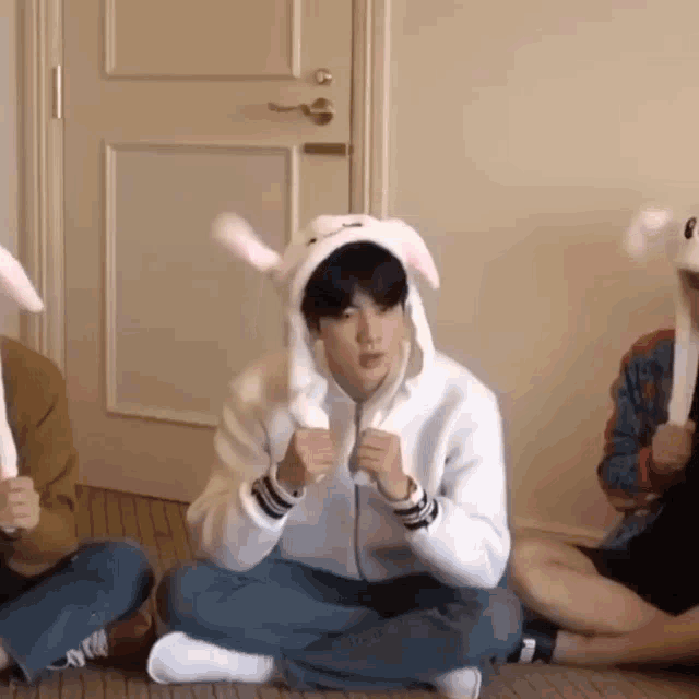 a group of people are sitting on the floor wearing bunny ears .