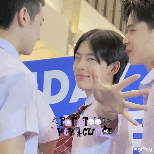 a group of young men are standing in front of a sign that says potato kitty girl