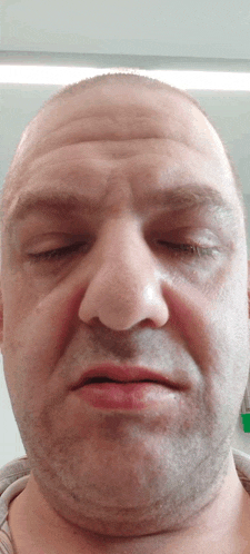 a close up of a man 's face with his eyes closed and a beard