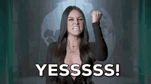a woman is holding her fist up in the air and says yesssss .
