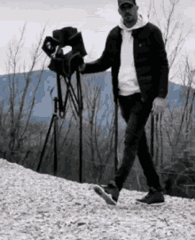 a man is walking down a snowy hill with a camera .