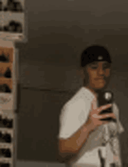 a man is taking a selfie in front of a mirror with his cell phone .