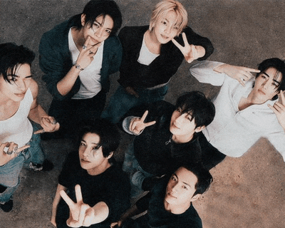 a group of young men are posing for a picture and one of them is giving a peace sign