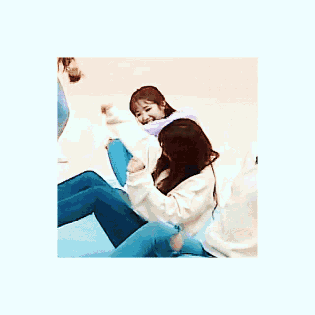three girls are sitting on a couch and one of them is playing with her hair .
