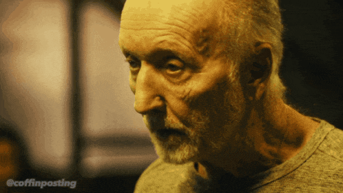 a close up of an older man with a beard and the words @coffinposting behind him