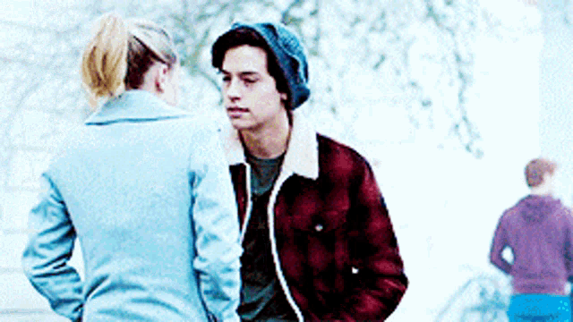 a man and a woman are standing next to each other and looking at each other