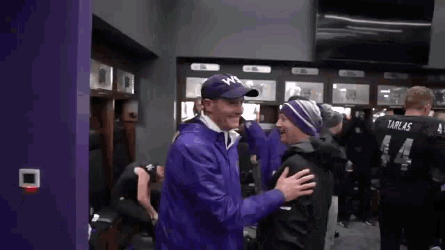a man in a purple jacket with the number 14 on his back
