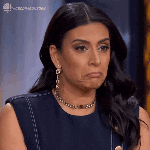 a woman wearing dior earrings makes a face