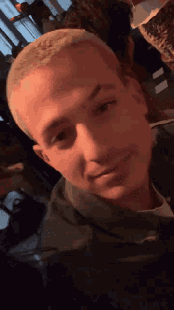 a close up of a man 's face with a shaved head