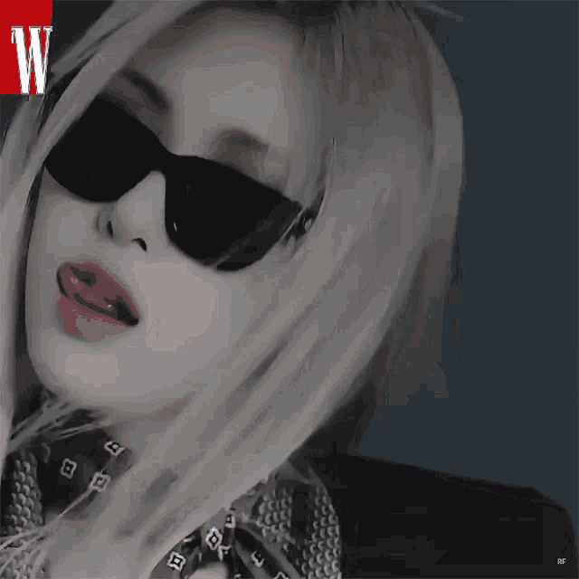 a woman wearing sunglasses and a scarf with the letter w on the bottom