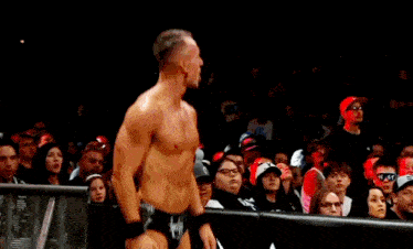 a wrestler in a black and white trunks with the letter r on the side