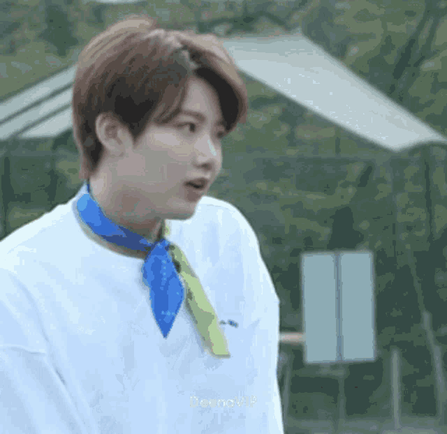 a young man wearing a blue scarf around his neck