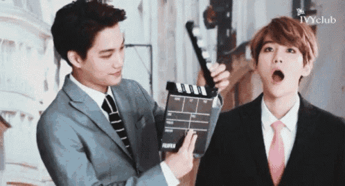 a man in a suit and tie is holding a clapper board with the word fujifilm on it