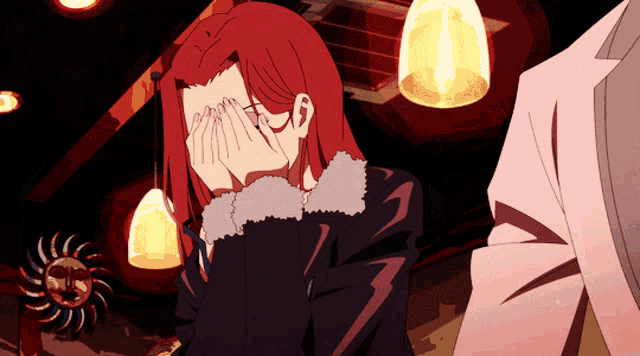 a woman with red hair covers her face with her hands