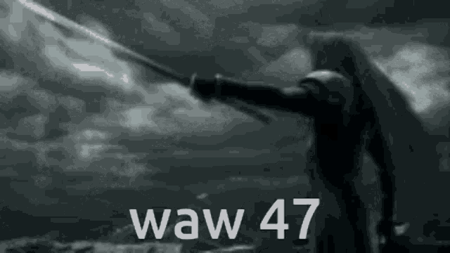 a black and white photo of a man holding a sword with the words waw 47 written on it .