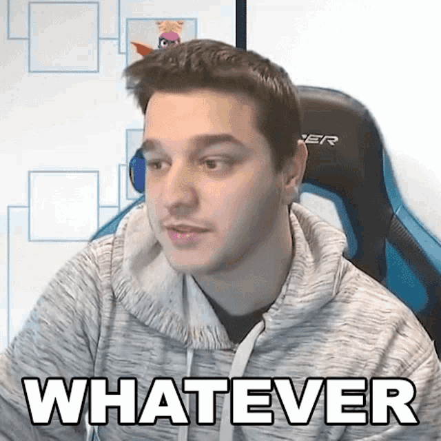 a young man is sitting in a gaming chair and making a funny face .