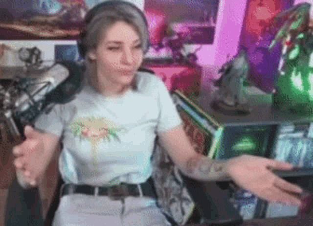a woman wearing headphones is sitting in front of a microphone in a room .