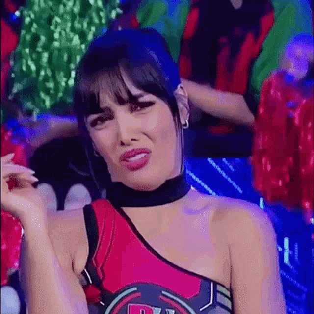 a woman in a red and black outfit is making a face .