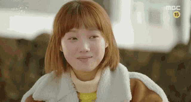 a close up of a woman making a funny face while wearing a fur coat .