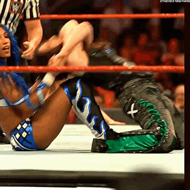 a woman in a blue and white outfit is wrestling another woman