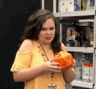 a woman wearing a lanyard that says hub city is holding an orange dice