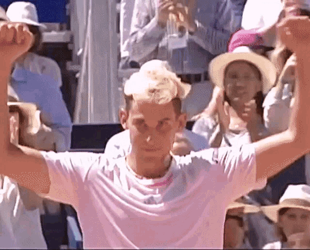 a man in a white shirt is holding his arms up in the air .