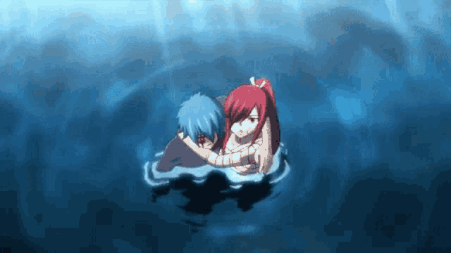 a boy and a girl are floating in the water and hugging each other .