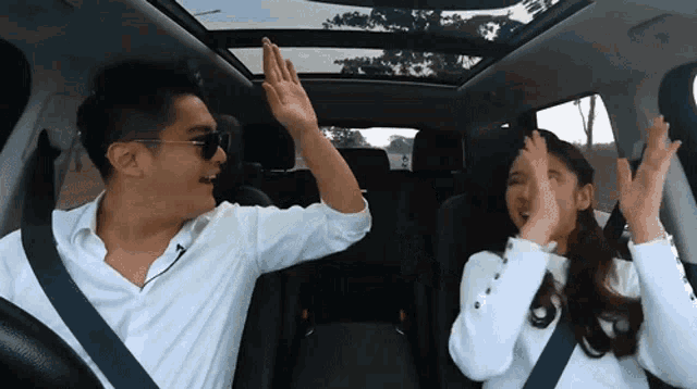 a man and a woman are giving each other a high five
