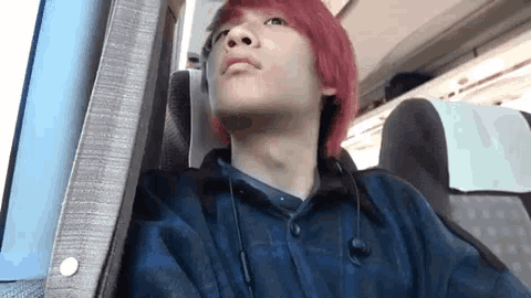 a young man with red hair is wearing headphones and a plaid shirt