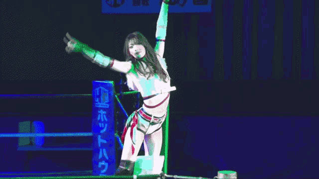 a woman in a wrestling ring with her arms in the air .