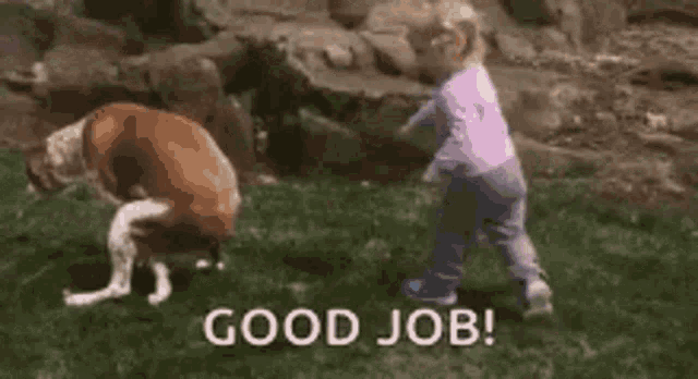 a little girl is playing with a dog in the grass and says `` good job ! ''