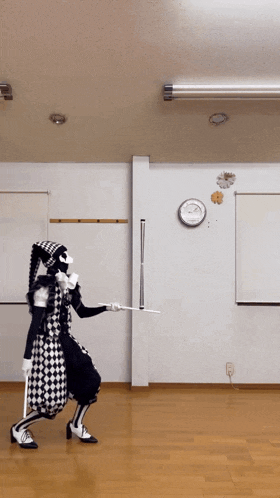 a person in a black and white costume is holding a stick