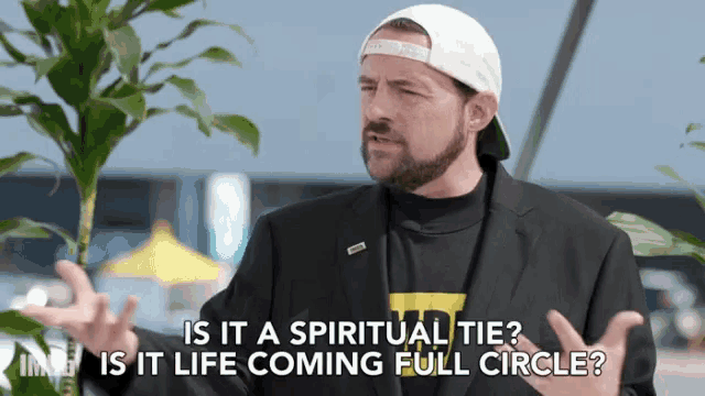 a man in a suit and hat is talking about spirituality and life coming full circle